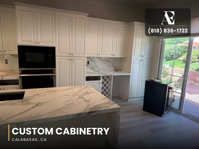 White raised-panel custom cabinets with built-in wall ovens and a wine rack in a Calabasas kitchen remodel