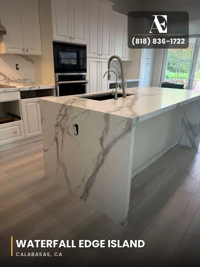 Kitchen island with a waterfall-edge marble-look stone countertop and undermount sink in Calabasas, CA